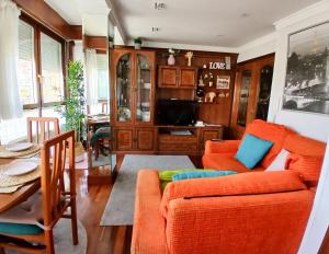 a living room with an orange couch and a table at mariajesus etxea in Bermeo