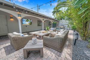 a patio with wicker chairs and tables on a patio at Surf KeySteps from Beach Beautiful Courtyard Hot Tub H0MES in Fort Lauderdale