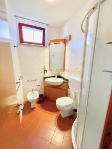 a bathroom with a toilet and a sink and a mirror at Bilocali Perseo in Marina di Bibbona +25 photos