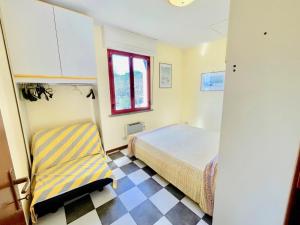 a bedroom with a bed and a chair in it at Bilocali Perseo in Marina di Bibbona