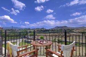 a table and chairs on a balcony with a view at Endless View in Mythimna
