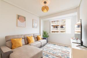 a living room with a couch and a television at Eguzkilore - baskeyrentals in Lekeitio