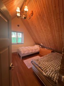 a attic room with two beds and a window at Half-timbered house in Österlen in Sjöbo