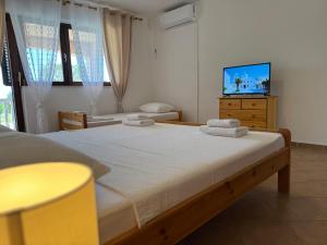 a bedroom with a bed and a flat screen tv at Apartments Bernarda 1 in Nin