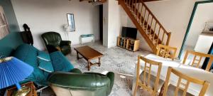 a living room with green furniture and a staircase at Le Duplex Charentais in Saint-Jean-dʼAngély