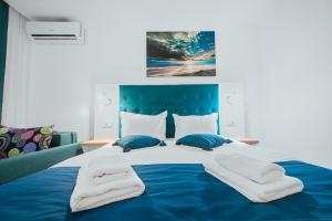 a large blue bed with white sheets and blue pillows at Complex Sea Star 2Mai in 2 Mai +54 photos