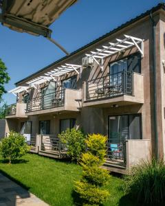 an apartment building with balconies and a yard at Complex Sea Star 2Mai in 2 Mai