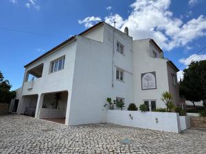 een wit gebouw op een geplaveide straat bij Cegonha Villa powered by Cegonha Resort- Private swimming pool & air con in Albufeira