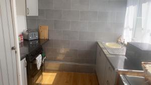 a small kitchen with a sink and a stove at Mountain View, Brecon Beacons in Trefeinon Station