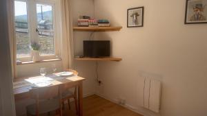 a room with a table and a television and a window at Mountain View, Brecon Beacons in Trefeinon Station