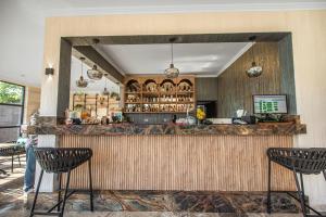 a restaurant with a bar with three chairs at Complex Sea Star 2Mai in 2 Mai