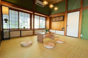 Habitación grande con mesa y algunas ventanas. en 古民家美ら 鴨川, en Kamogawa