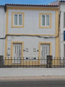a white building with three doors and a fence at Charming Benavente in Benavente