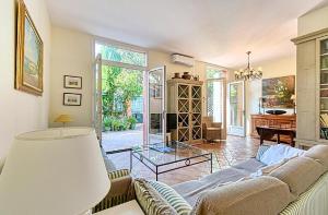 Una sala de estar con un sofá y una mesa de cristal. en L'ORANGER maison pittoresque et confortable proche des plages, Croisette et centre-ville, en Cannes