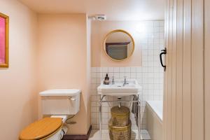 a bathroom with a toilet and a sink and a mirror at Bertie's Cottage by Keepers Cottages in Robertsbridge