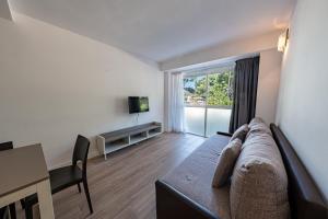a living room with a couch and a table and a television at Park Suites Family Rentalmar in Salou
