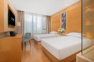 a hotel room with two beds and a television at 杭州西湖6698水晶设计酒店 in Hangzhou