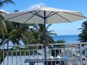 a table with an umbrella on the beach at Casa Vina El Nido in El Nido +11 photos
