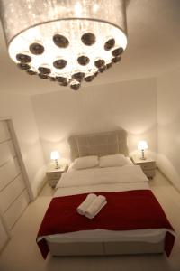 a bedroom with a large bed and a large chandelier at Panorama Suite in Galaţi