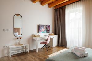 een slaapkamer met een bureau, een bed en een spiegel bij Richter Residence in Braşov