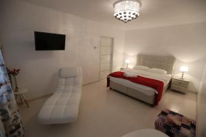 a bedroom with a bed and a chair and a television at Panorama Suite in Galaţi