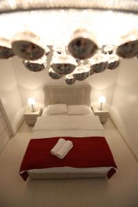 a bedroom with a bed with a red blanket and two lights at Panorama Suite in Galaţi