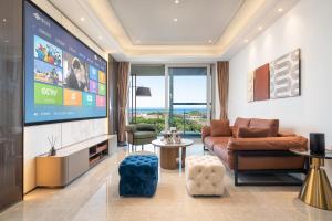 a living room with a large tv and a couch at 三亚海棠湾蔚蓝海湾公寓 in Sanya