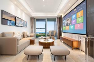 a living room with a couch and a tv at 三亚海棠湾蔚蓝海湾公寓 in Sanya