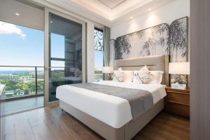 a bedroom with a large bed and a large window at 三亚海棠湾蔚蓝海湾公寓 in Sanya