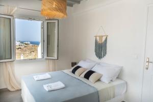 sypialnia z łóżkiem i dwoma ręcznikami na nim w obiekcie Thalia Luxe 4-Bedroom Pool Villa w mieście Mykonos