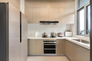 a white kitchen with a stove and a sink at 三亚海棠湾蔚蓝海湾公寓 in Sanya