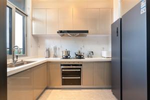 a kitchen with white cabinets and a stove top oven at 三亚海棠湾蔚蓝海湾公寓 in Sanya