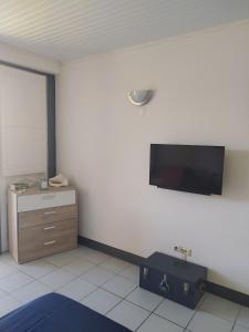 a room with a flat screen tv on a wall at Joli Studio à 5 min de la plage in Sainte-Anne