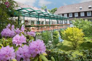 un jardin avec des fleurs roses devant un bâtiment dans l'établissement Ringhotel Fährhaus, à Bad Bevensen