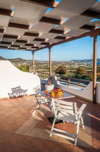 a patio with a table and chairs on a roof at Oceanis Rooms in Adamas