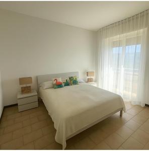 Un dormitorio blanco con una cama grande y una ventana. en DreamLiving Vasto 1st, en Vasto