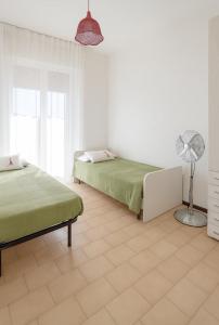 Habitación blanca con 2 camas y ventilador. en DreamLiving Vasto 1st, en Vasto