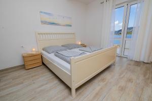 a bedroom with a bed with two candles on it at Apartmani Katarina in Pupnat