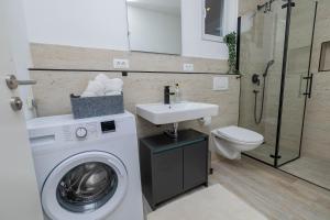 a bathroom with a washing machine and a sink at Apartmani Katarina in Pupnat +46 photos