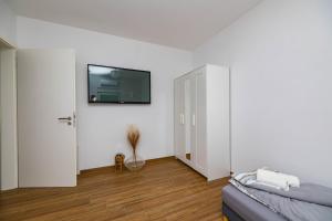 a living room with a couch and a tv on the wall at Apartmani Katarina in Pupnat
