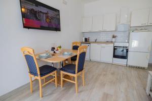 a kitchen with a table and chairs and a refrigerator at Apartmani Katarina in Pupnat