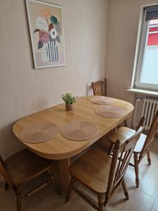 a wooden table with four chairs around it at Charming apartment in the countryside in Calden