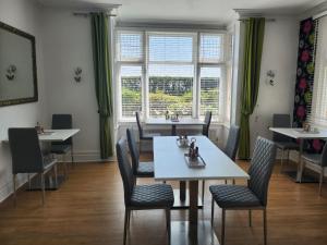 a dining room with tables and chairs and a window at South Beach B & B in Lowestoft