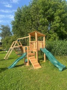 a wooden playground with two slides and a ladder at Het Spoel in Kuilenburg