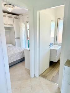 a bedroom with a bed and a bathroom with a sink at Isabel Apartment in Porto Azzurro