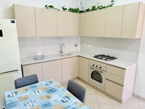 a kitchen with a table and a sink and a stove at Isabel Apartment in Porto Azzurro