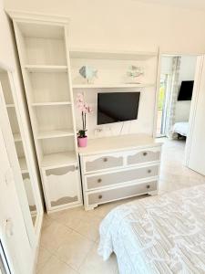 a bedroom with a white dresser with a tv on it at Isabel Apartment in Porto Azzurro +5 photos