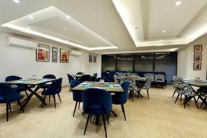 a dining room with tables and chairs in a room at OPO Iffco Chowk, Gurgaon in Gurgaon