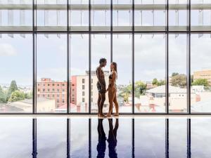 ホバートにあるイビス スタイル ホバートの大きな窓の前に立っているカップル