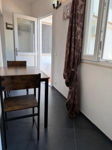 a table and a chair in a room with a window at Tosk House in Peschici